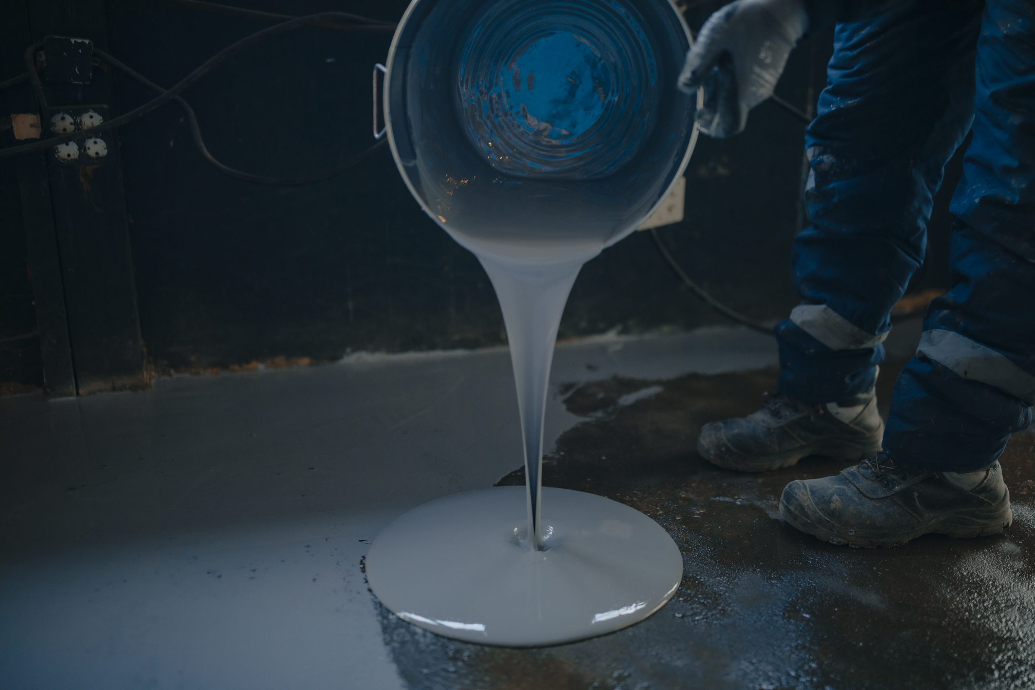 The worker applies gray epoxy resin to the new floor